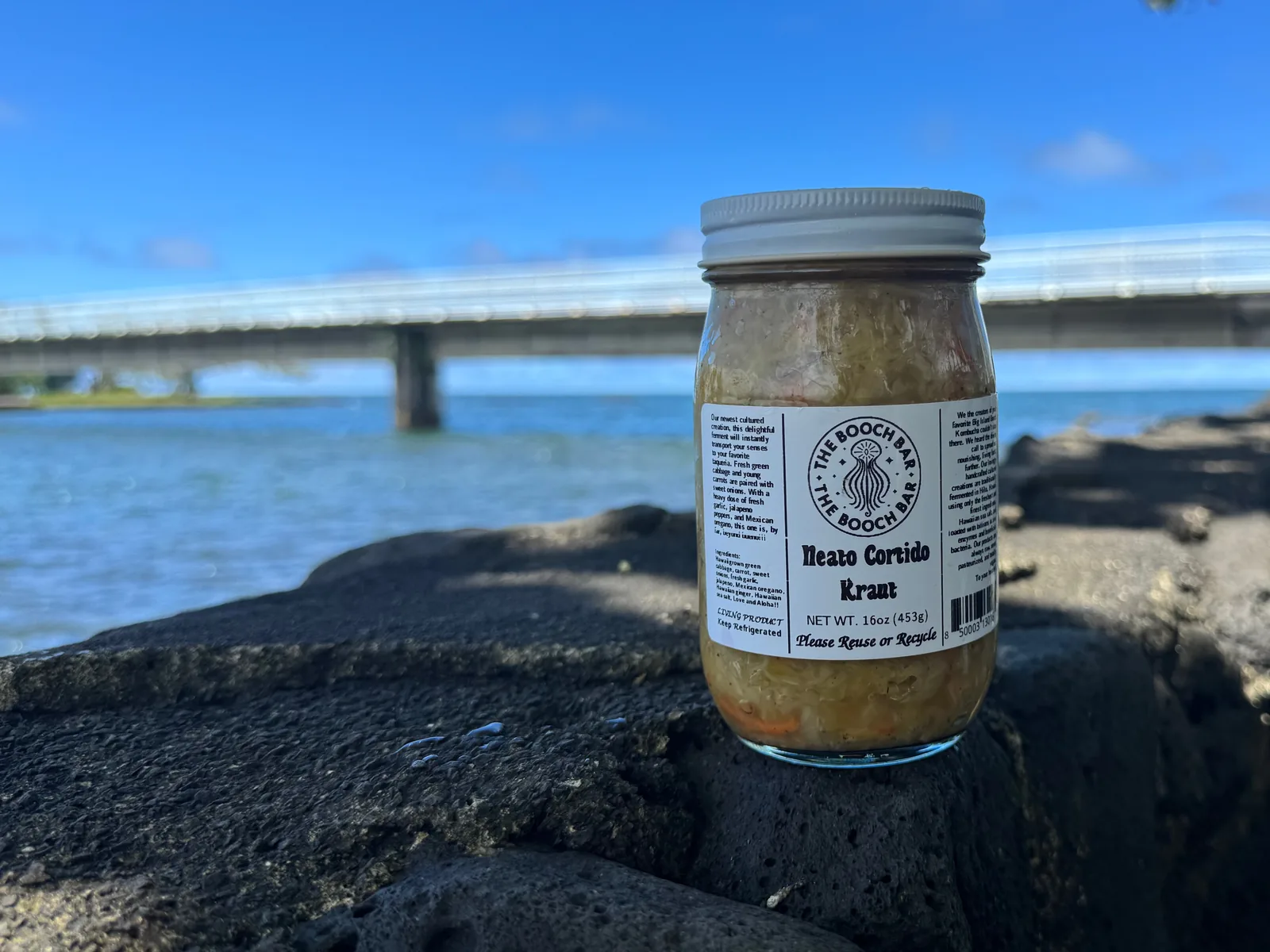 A 16 oz jar of Big Island Booch Neato Cortido kraut on lava rock at Hilo Bay